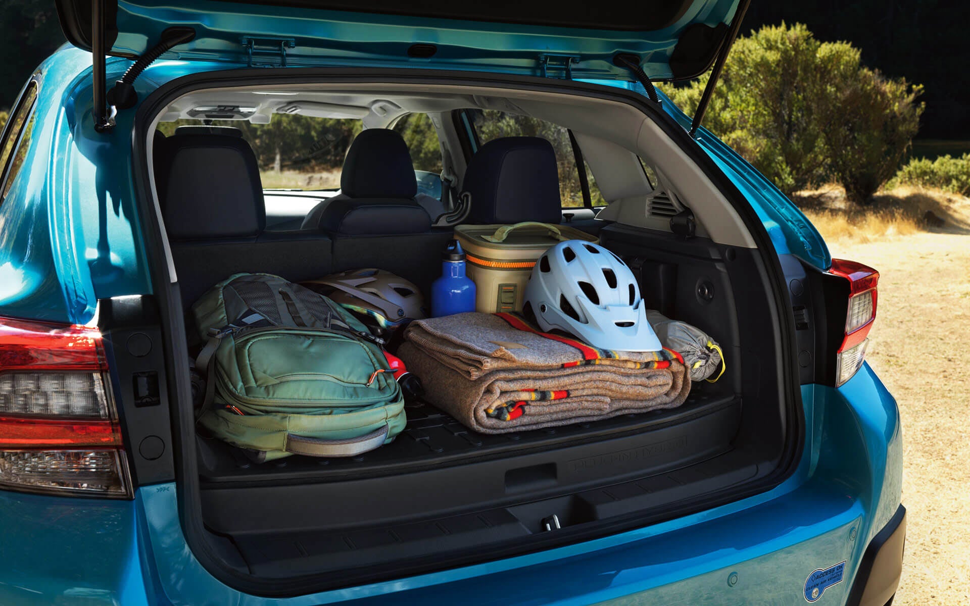 A backpack, blanket, and bike helmet in the rear cargo area of a Crosstrek Hybrid | Burke Subaru in Cape May Court House NJ