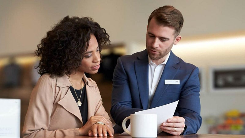 Dealership employee discussing insurance with customer