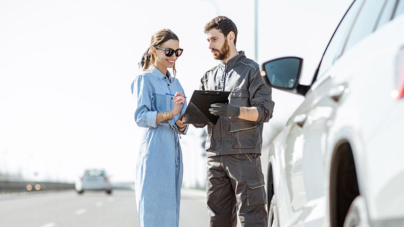 Roadside assistance technician helping vehicle owner